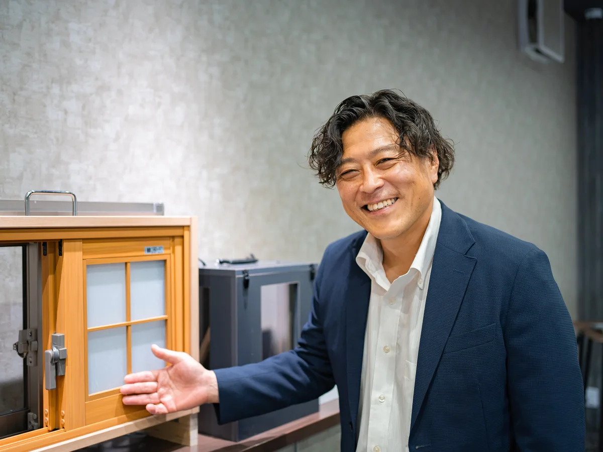 ショールームで窓のサンプルを前に説明するマドレストのスタッフ