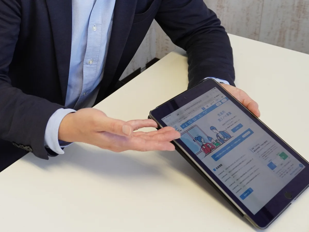 タブレットで補助金の申請ページを示すマドレストのスタッフの手元